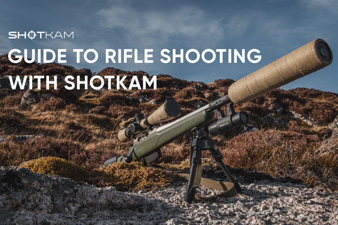 Scoped hunting rifle with ShotKam action camera in mountain landscape