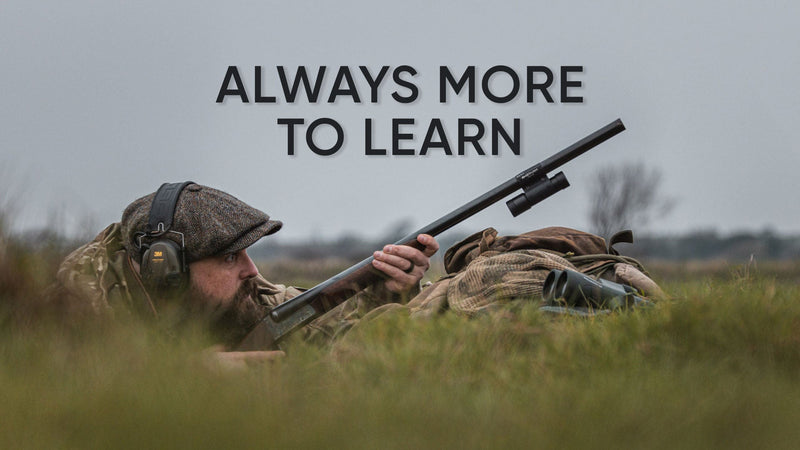 Tom Sykes lying in a grassy field with his ShotKam-equipped shotgun beneath the words “Always More to Learn.”