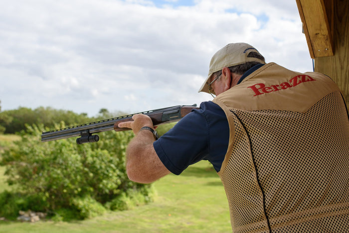 Sporting clays shooter in action with a shotgun, focusing on techniques for approaching rabbit targets in the UK.