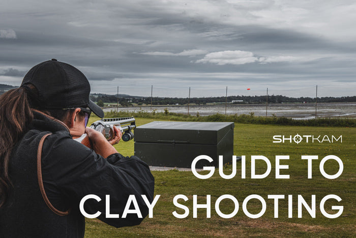 Woman practicing clay target shooting with a camera mounted on her shotgun