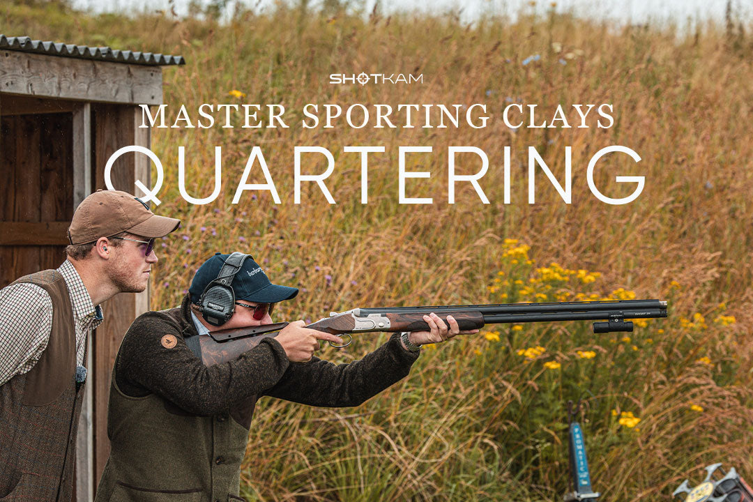 Shooting coach guiding a student aiming at quartering targets during a sporting clays session.